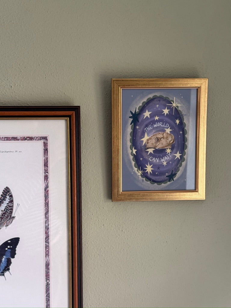 Framed artwork on a wall with a deer illustration